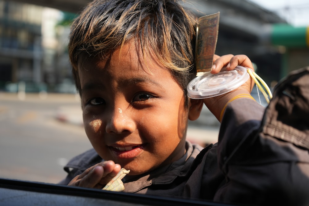 a young boy holding a piece of food in his hand