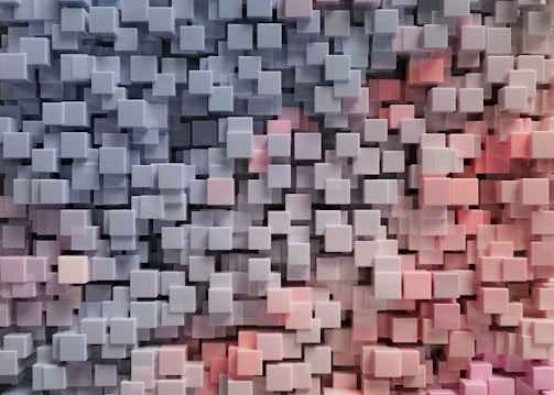 A dense cluster of three-dimensional cubes in varying shades of blue and pink, creating a geometric, abstract texture with depth and complexity.