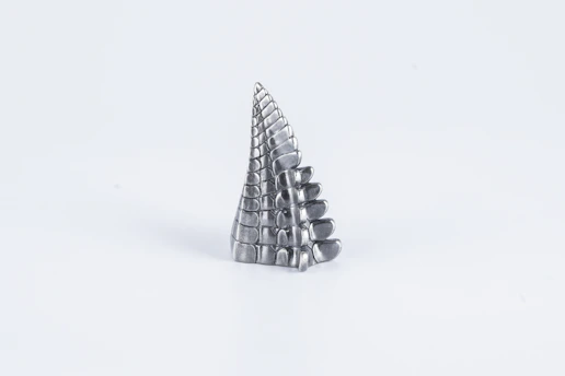 Close-up of a vibrant 3D-printed sculpture with intricate details and smooth texture, set against a minimalist background.