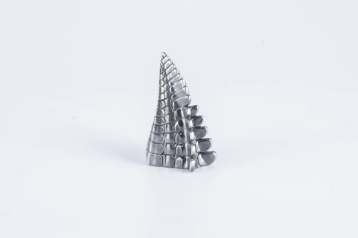 A bright, minimalist sculpture displayed against a white wall.