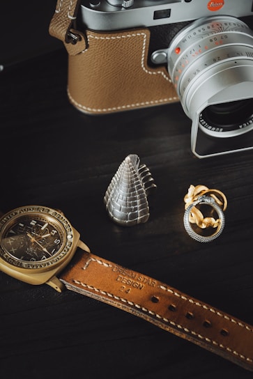 A close-up photo of vintage watches and silver bracelets displayed on a wooden table.