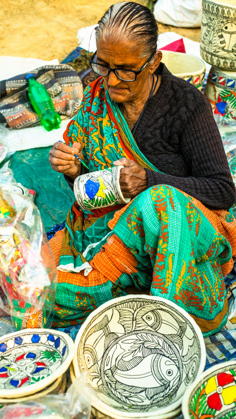 uma mulher sentada no chão trabalhando em uma obra de arte