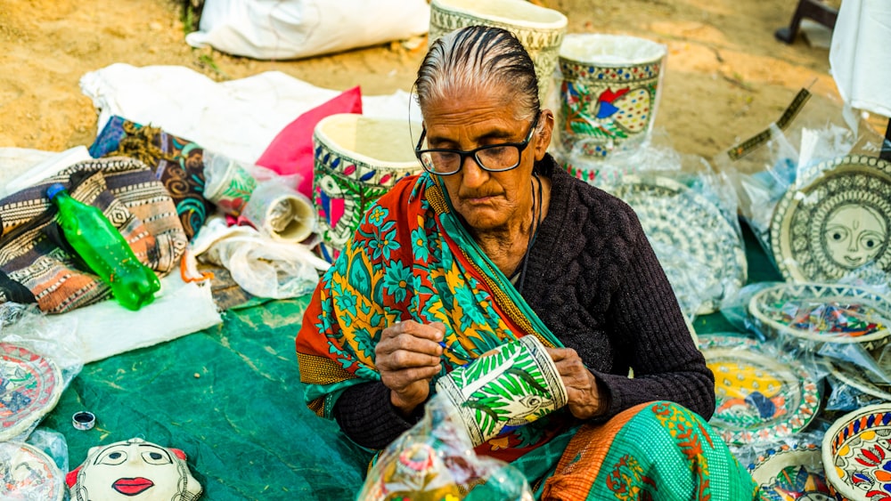 Une femme assise devant une table couverte de poterie