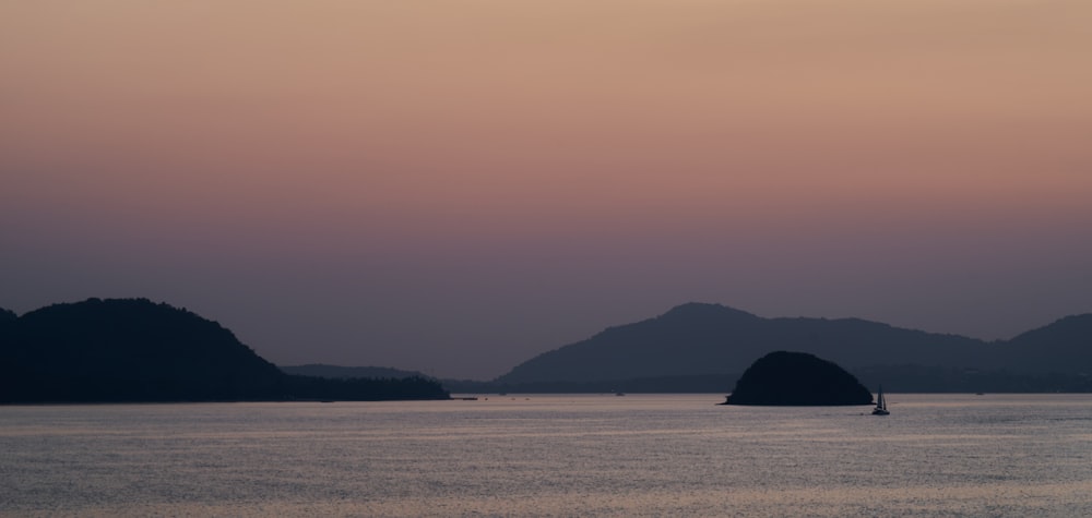 a large body of water with mountains in the background