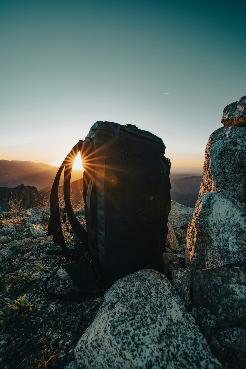 a backpack sitting on top of a rocky hill
