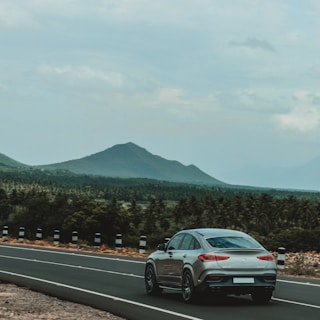 An electric car driving smoothly along a scenic coastal road.