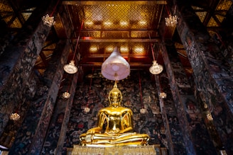 a large golden buddha statue sitting inside of a building