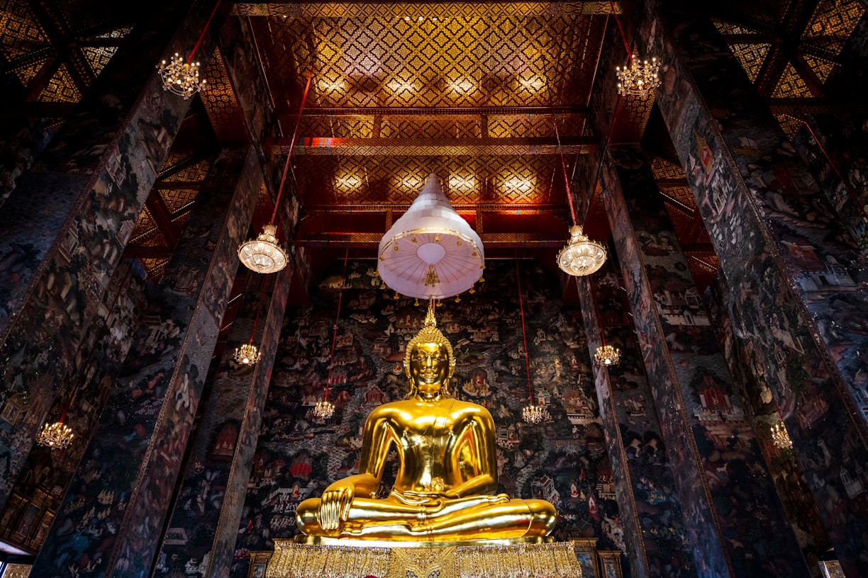 a large golden buddha statue sitting inside of a building