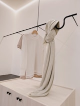 Hoodies and joggers displayed on minimalist hangers against a neutral background.