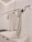 A minimalist clothing display with a white t-shirt on a wooden hanger and a beige knit scarf draped over a sleek black metal rod. The background is a clean, light-colored wall with subtle architectural lines.