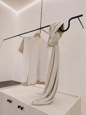 Stylish black shirt displayed on a minimalist mannequin with soft beige background.