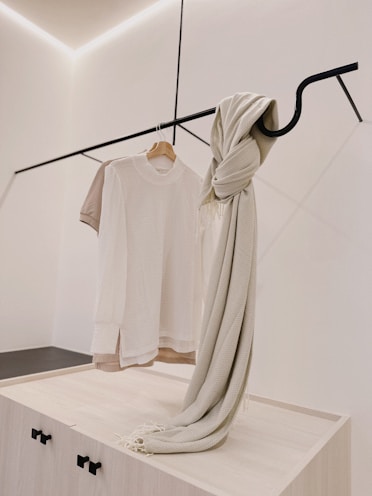 Minimalist accessories like bags and scarves arranged on a clean white surface.