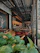 Cozy bistro interior with warm lighting and a beautifully plated Brazilian-Italian fusion dish on a rustic wooden table.