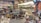 A colorful souvenir shop filled with various items including textiles, ceramics, clothing, hats, and bags. The shelves are densely packed with products like postcards, magnets, and other decorative pieces. Bright lighting highlights the vibrant assortment of items.