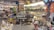 A colorful souvenir shop filled with various items including textiles, ceramics, clothing, hats, and bags. The shelves are densely packed with products like postcards, magnets, and other decorative pieces. Bright lighting highlights the vibrant assortment of items.