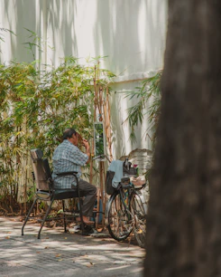 a man sitting on a chair next to a bike