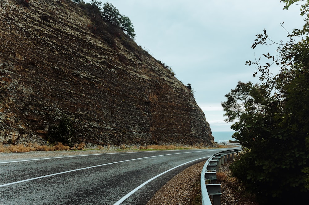 a road with a steep cliff in the background
