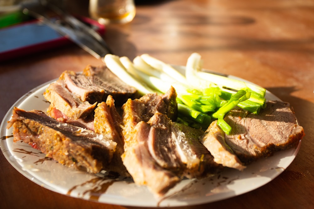 a white plate topped with meat and veggies