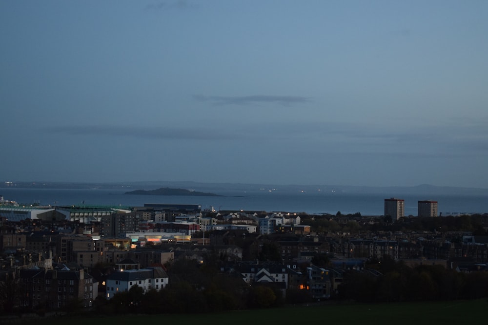 a view of a city at night with the ocean in the background