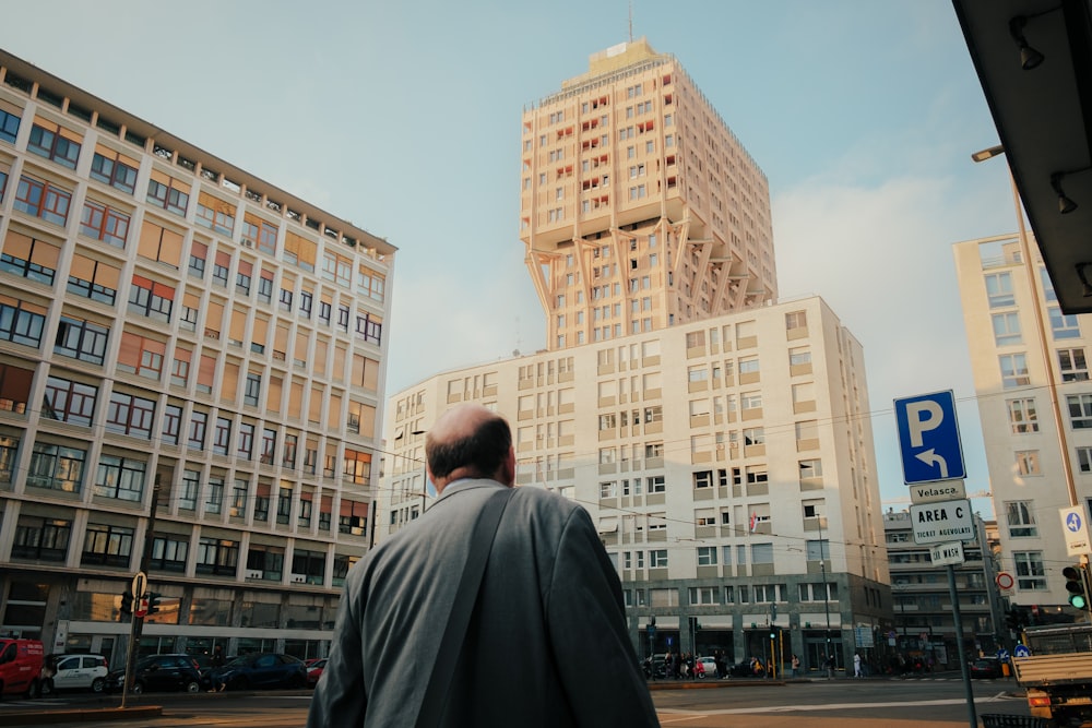 a man walking down a street in front of tall buildings