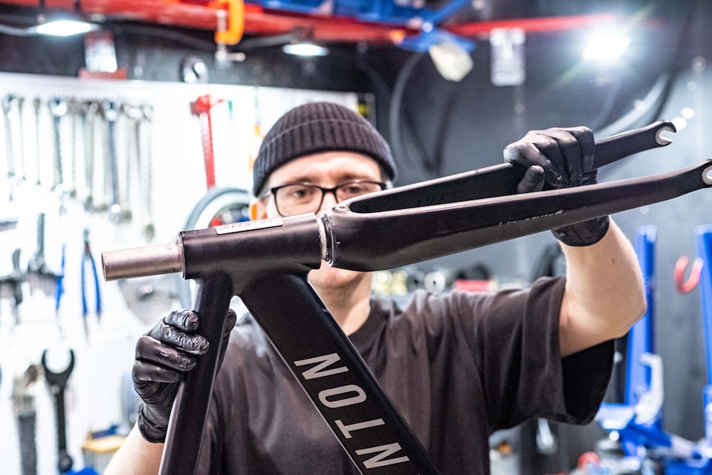 a man holding a bike in a garage