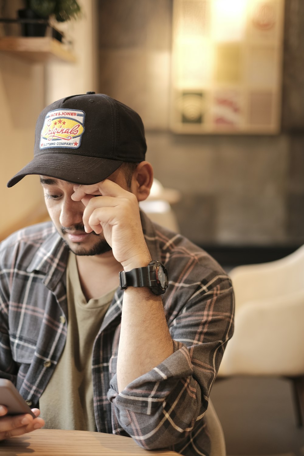 a man sitting at a table using a cell phone