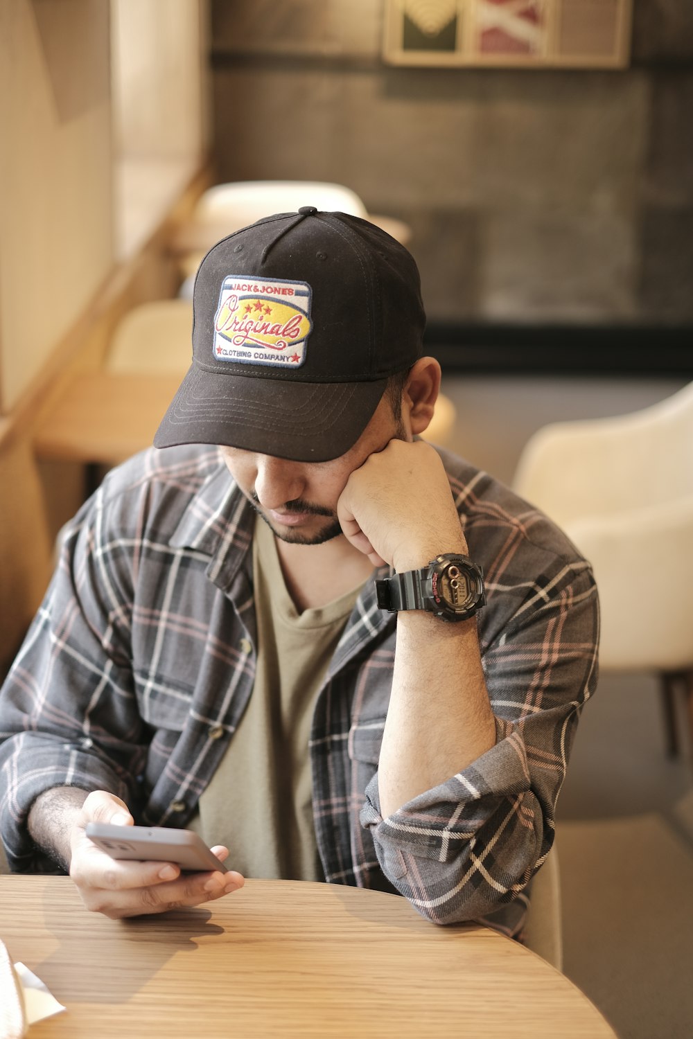 a man sitting at a table looking at his cell phone