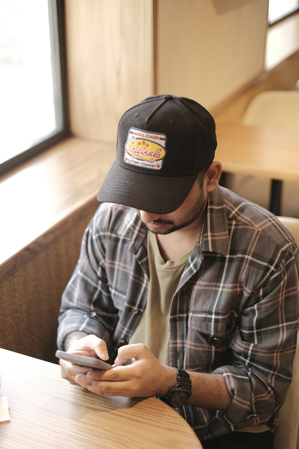 a man sitting at a table using a cell phone