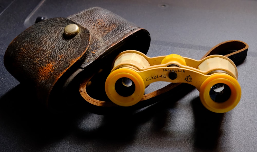 a pair of yellow binoculars sitting on top of a table