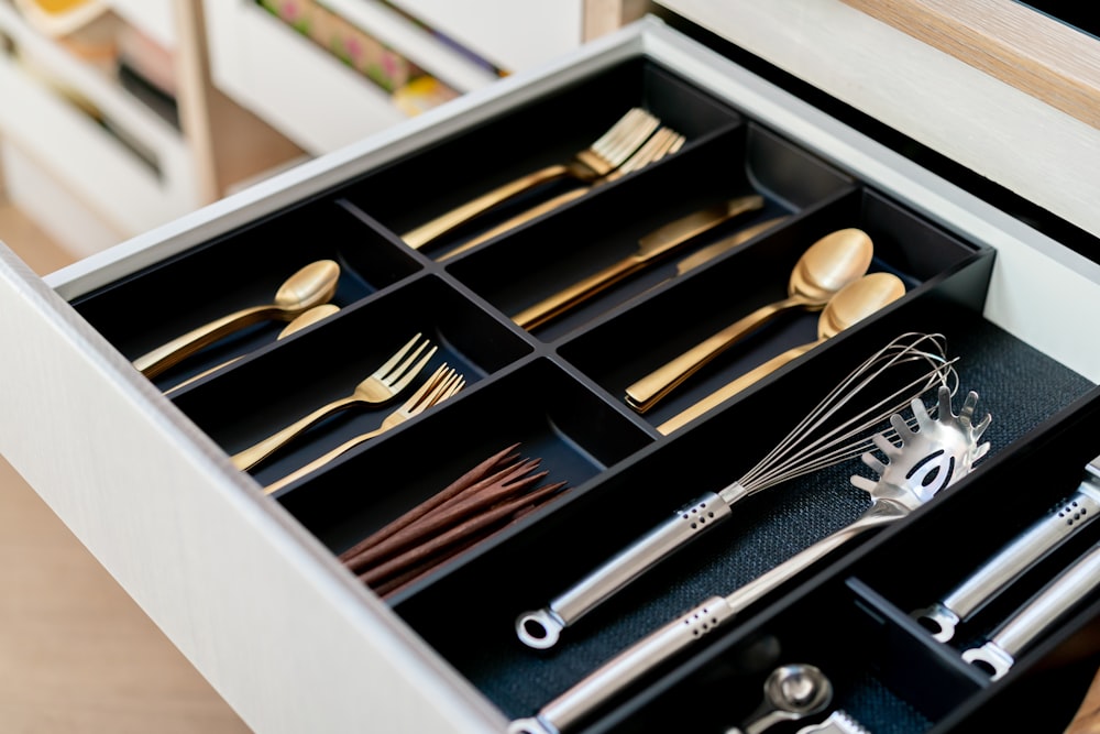 a drawer filled with silverware and wooden spoons
