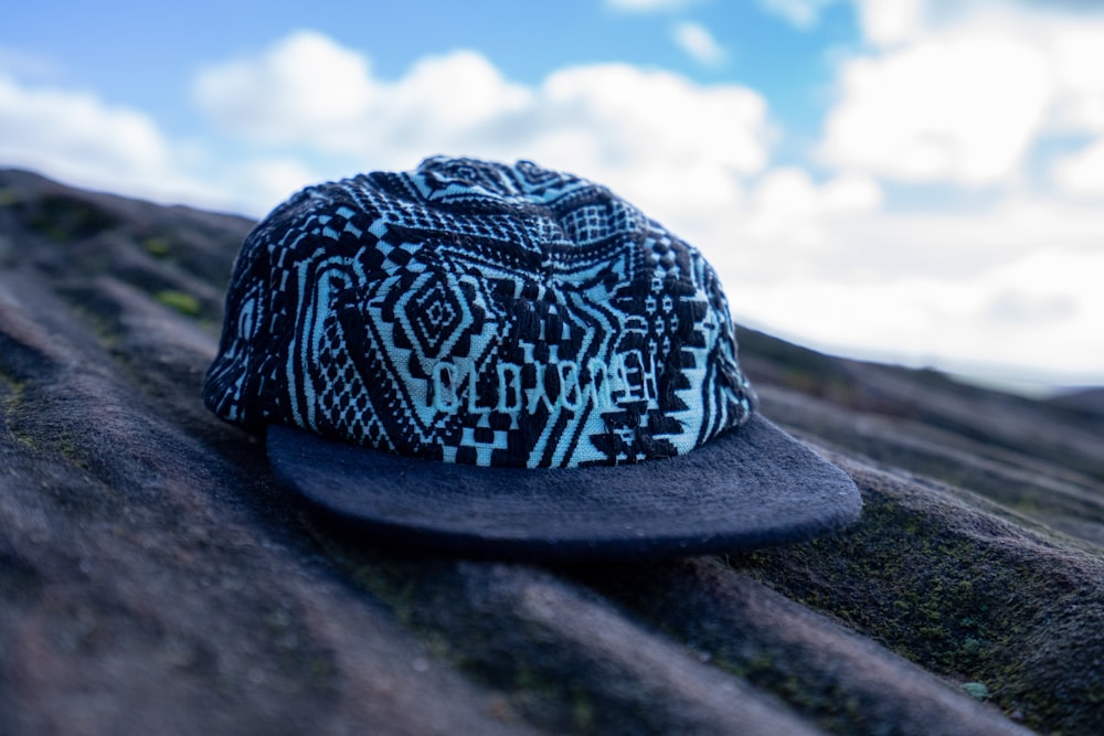 a blue and white hat sitting on top of a rock