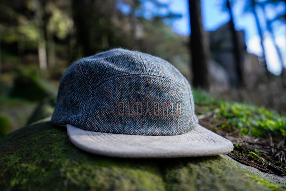 a hat sitting on top of a moss covered rock