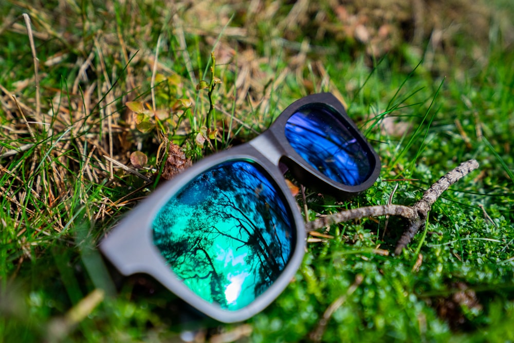 a pair of sunglasses sitting on top of a lush green field