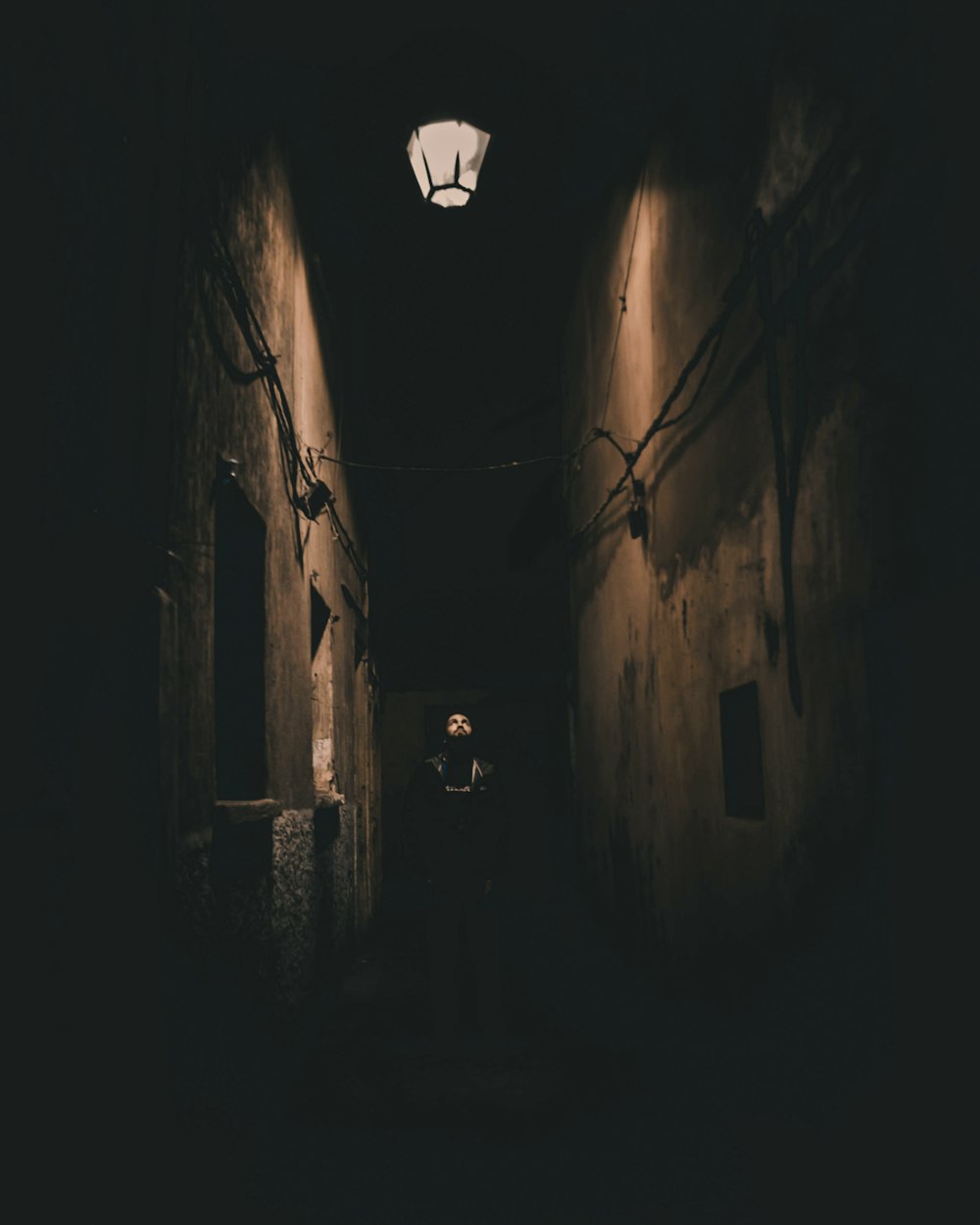 a dark alley way with a light on the ceiling