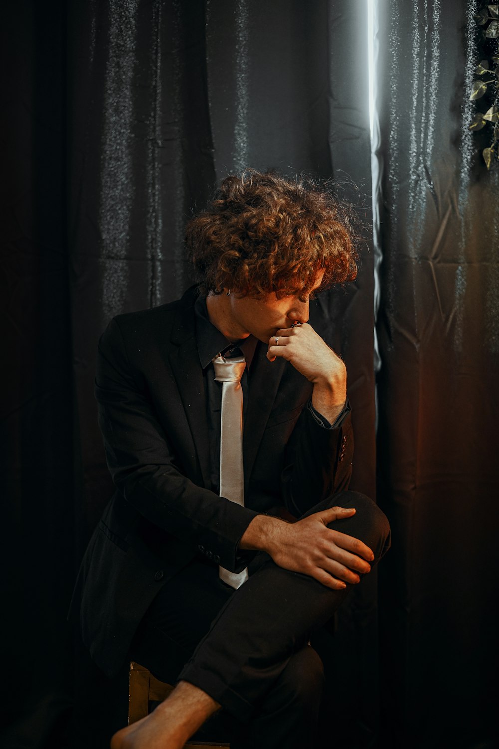 a man in a suit and tie sitting on a chair