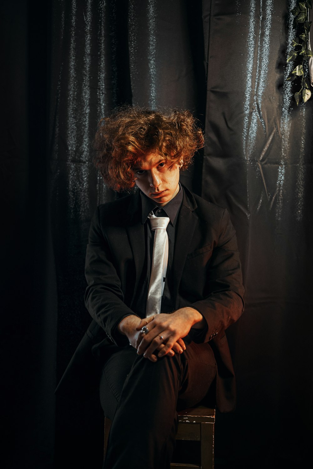 a man in a suit and tie sitting on a chair