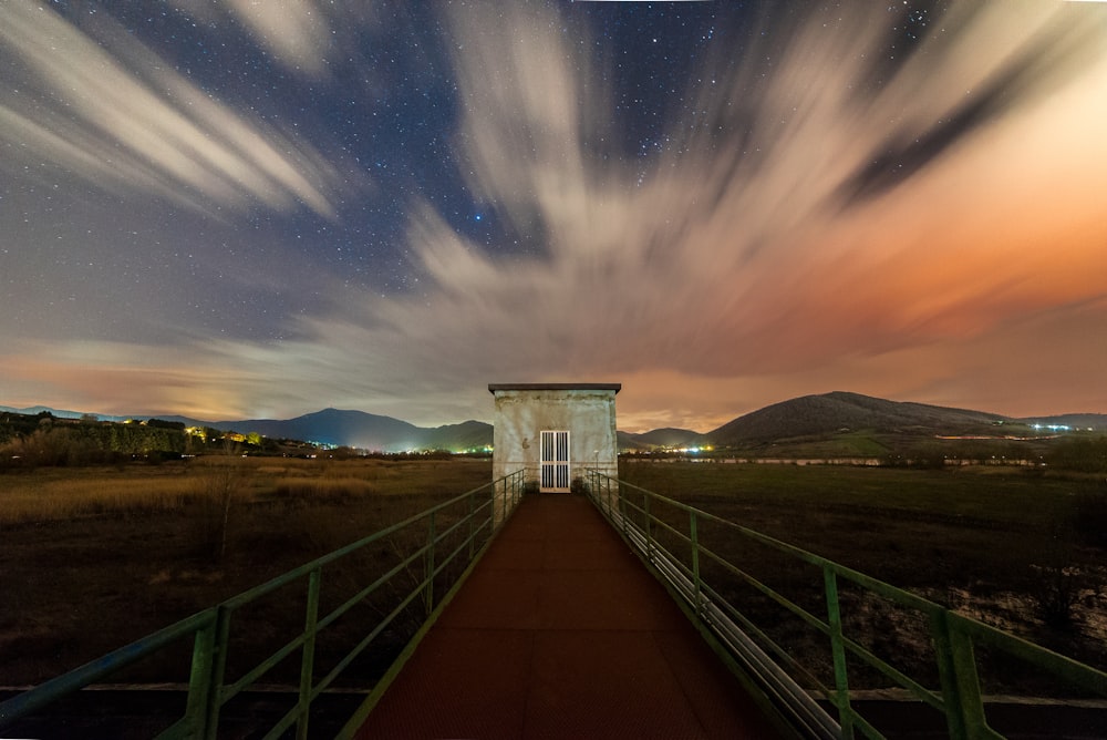 a long exposure of the night sky over a bridge