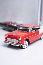 a red and white toy car sitting next to each other