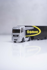 a toy truck with a trailer on a white surface