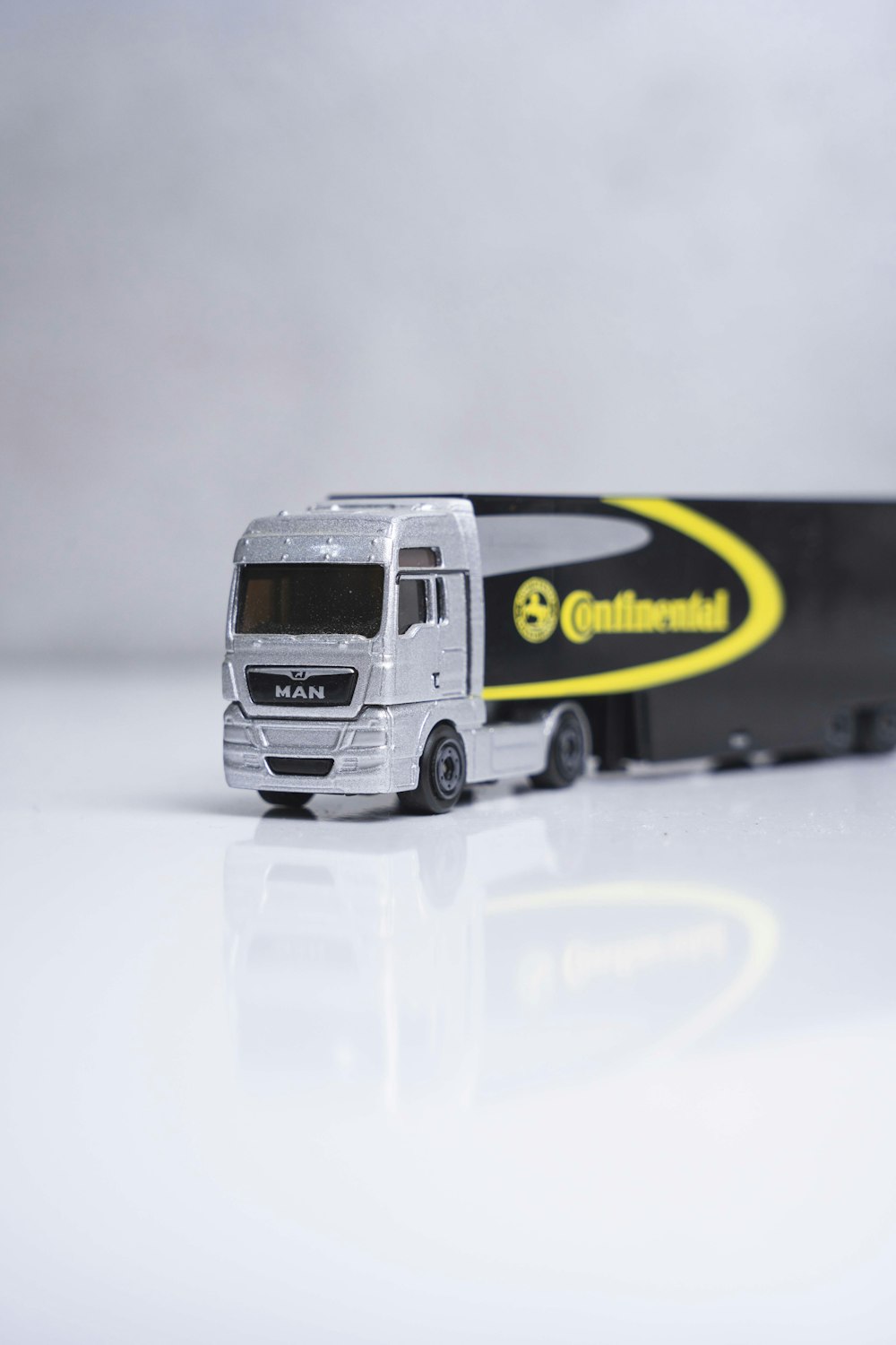 a toy truck with a trailer on a white surface
