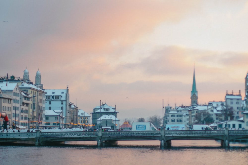 a bridge over a body of water with buildings in the background