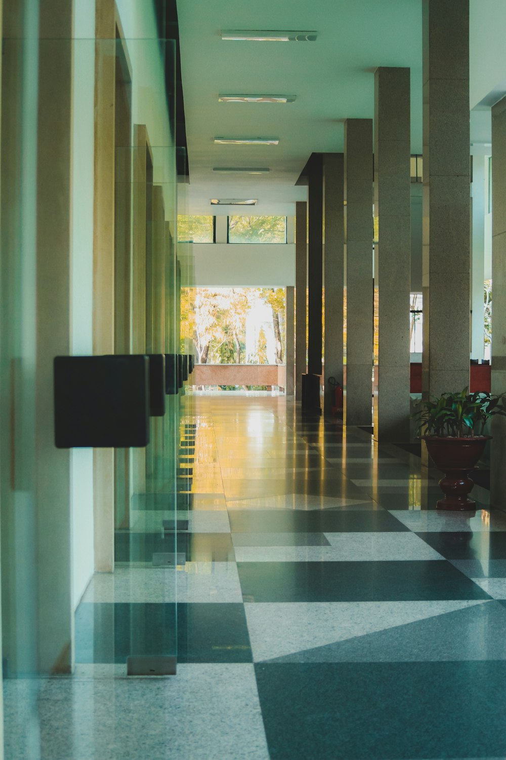 a hallway with a checkered floor and a clock on the wall