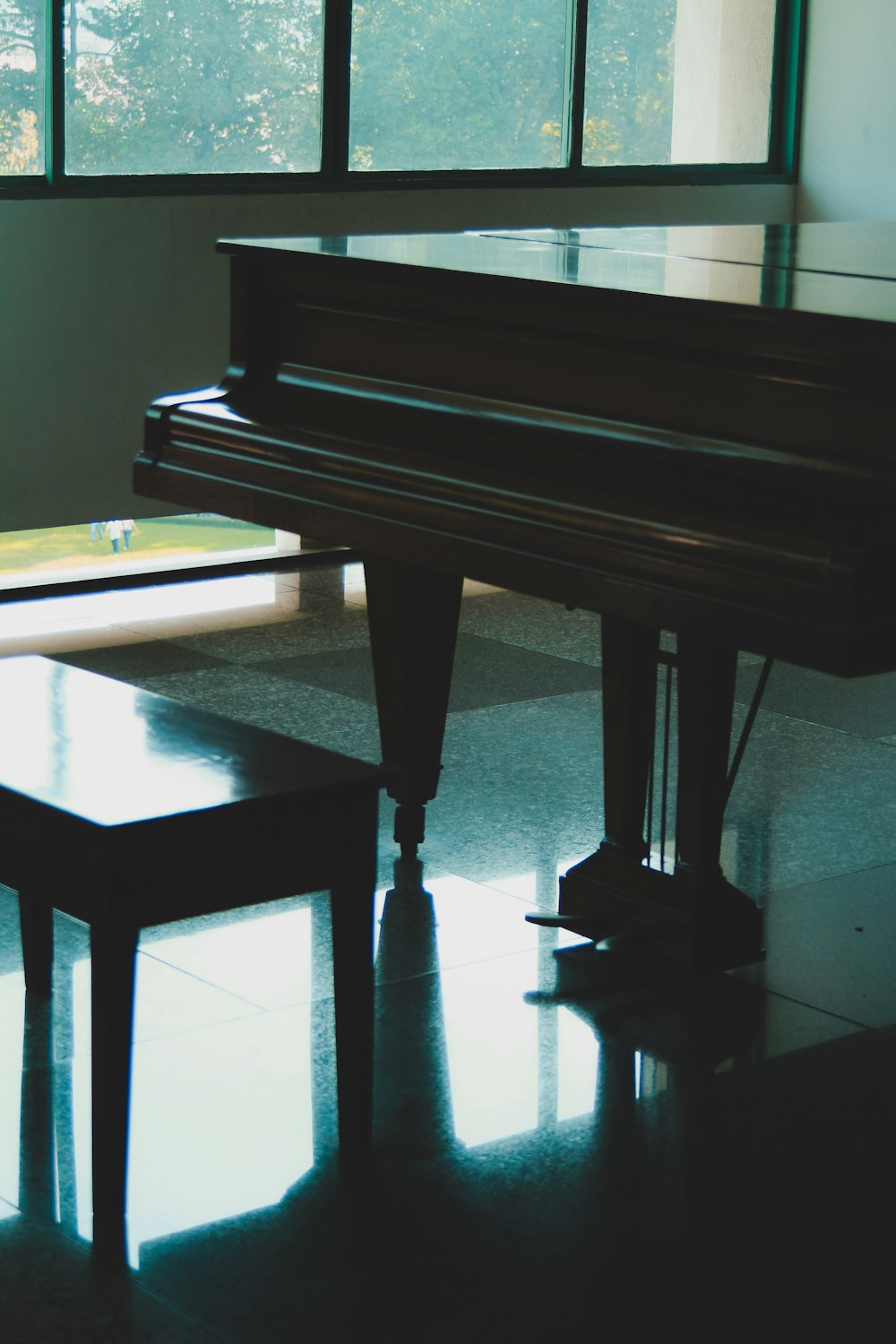 a piano sitting in a room next to a window