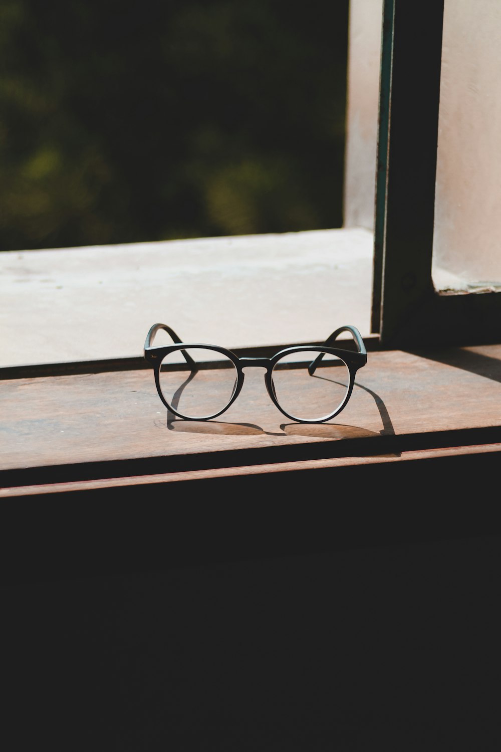 a pair of glasses sitting on top of a window sill