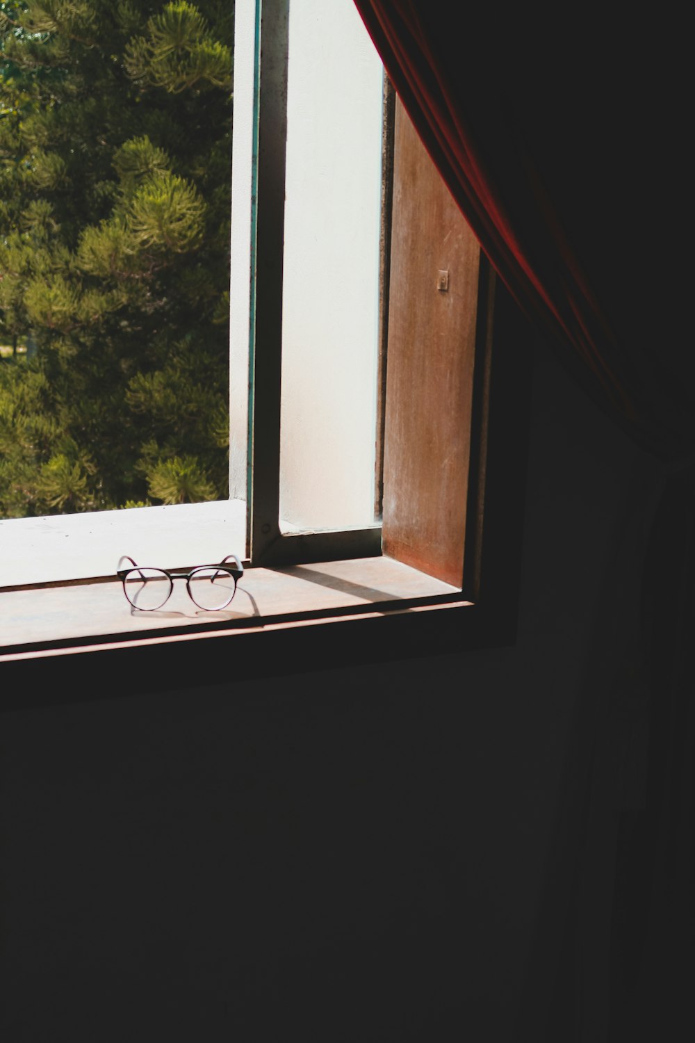 a pair of glasses sitting on top of a window sill