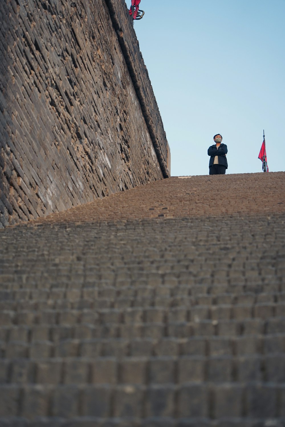 a man standing on top of a stone wall