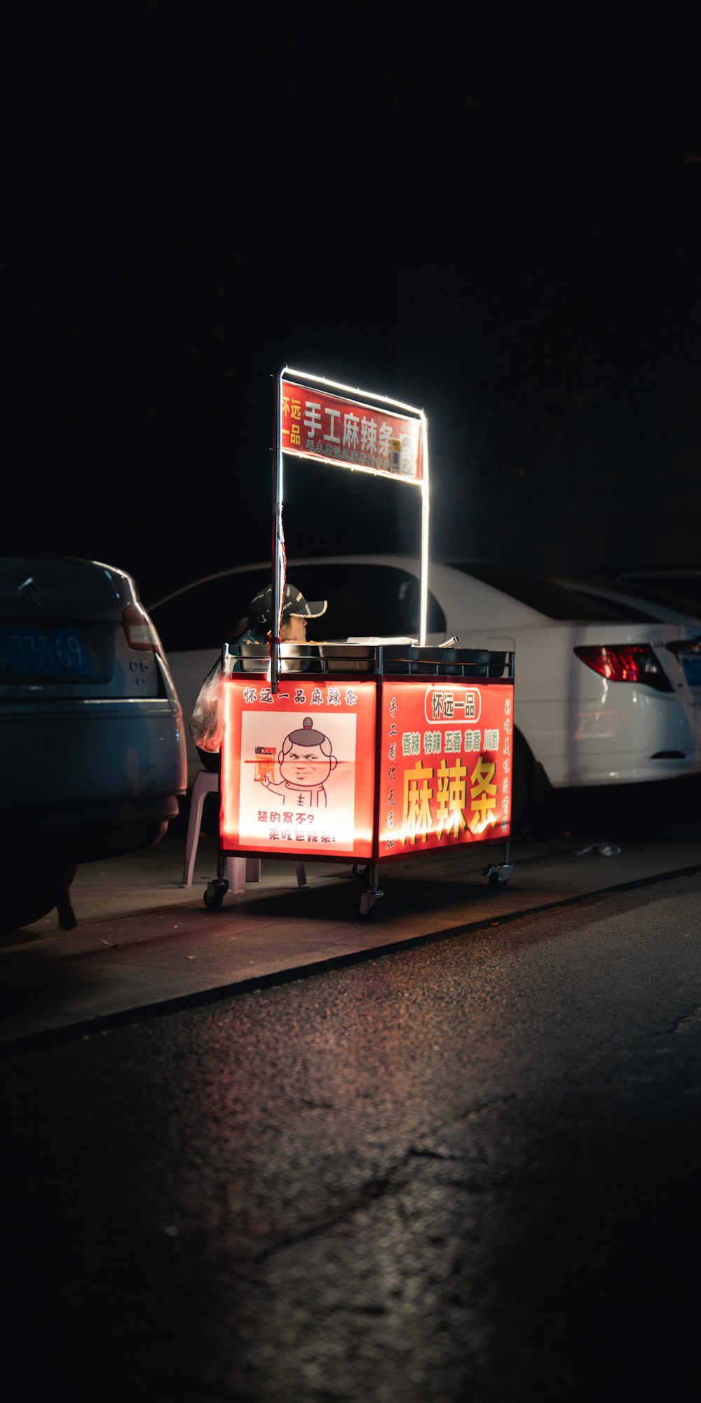 a food cart sitting on the side of a road at night