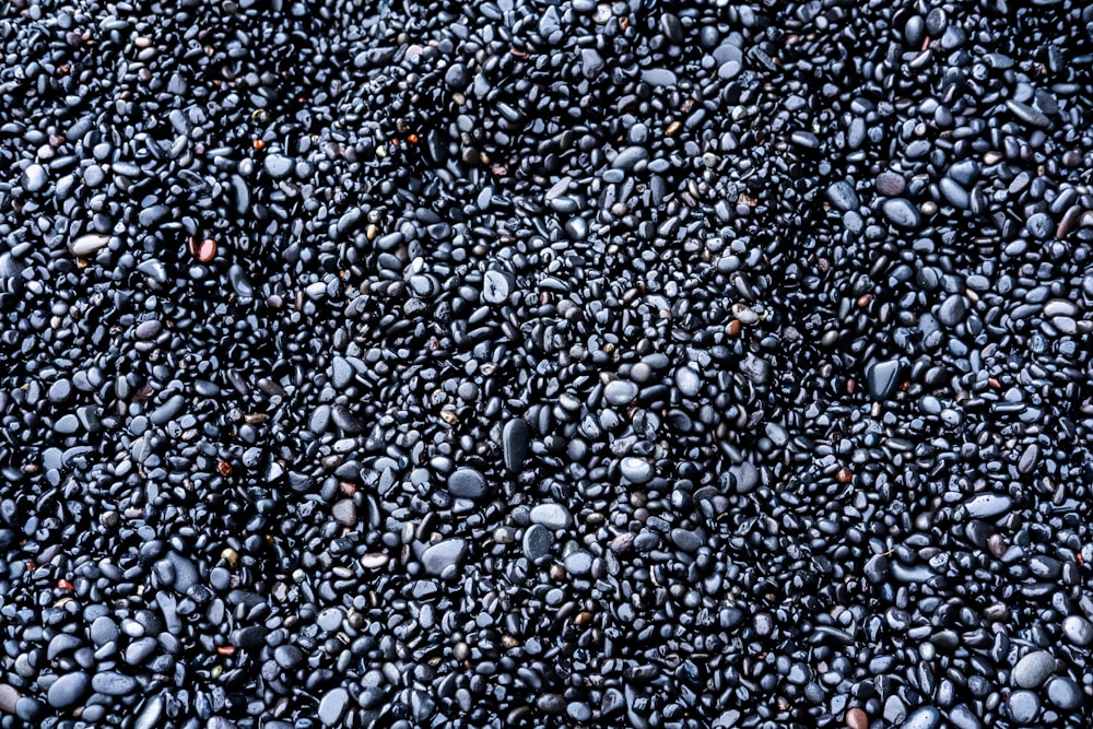a bunch of black rocks that are on the ground