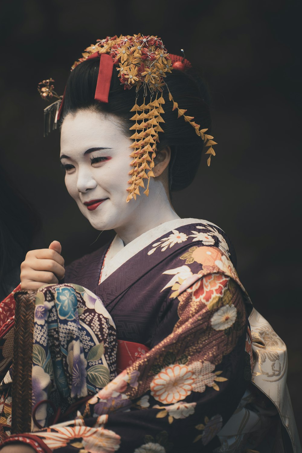a geisha woman in a kimono holding a basket