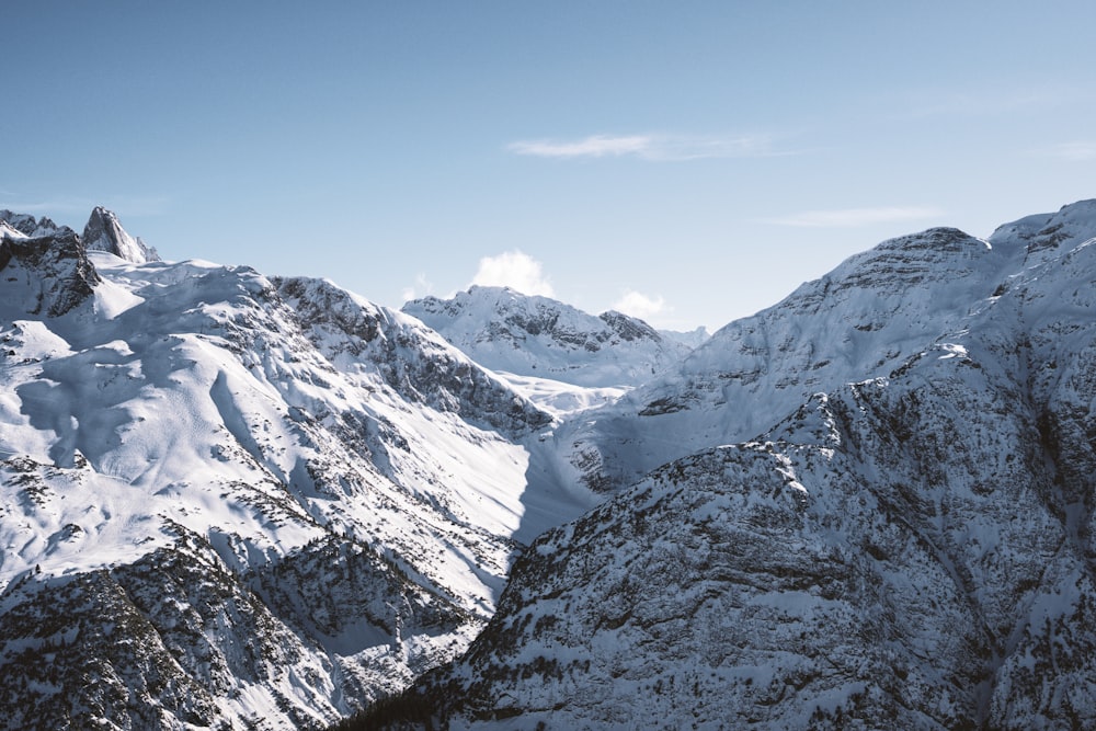 a mountain range covered in snow under a blue sky